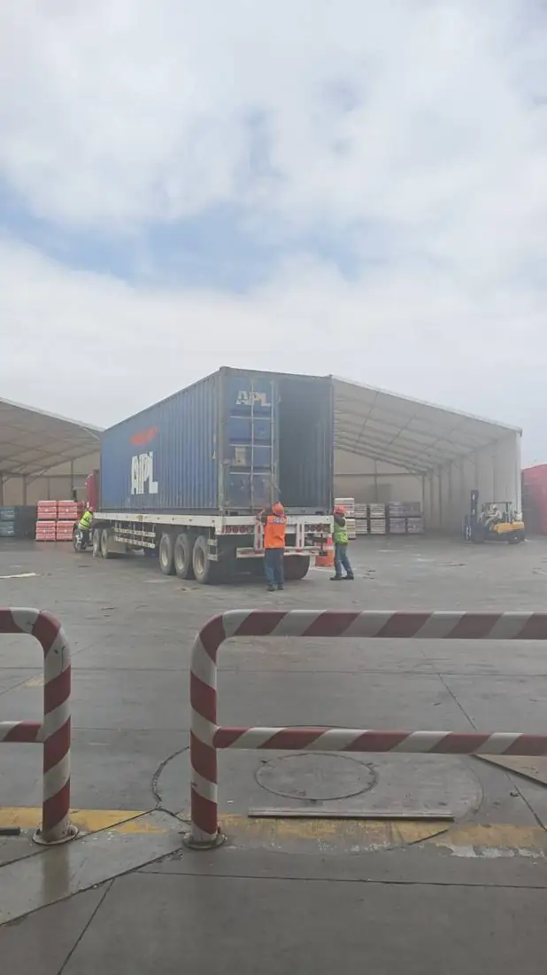 Operarios de Harraso Transport maniobrando un contenedor en el patio de almacén